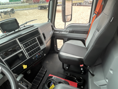 Dashboard and driver seat of a 2026 Mack MD6 truck cab interior, showing controls, steering wheel, center console, and seating.