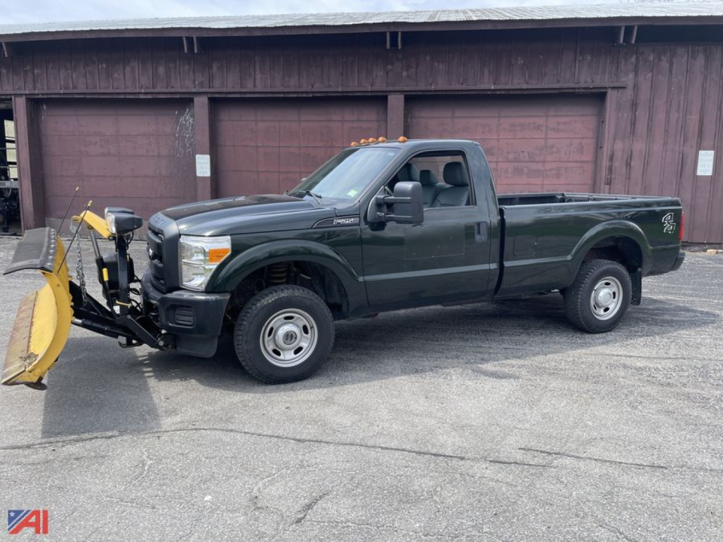 Ford F-250 XL Super Duty pickup with front plow attachment, dark green extended cab, side view showing plow mounting hardware and 4x4 pickup truck.