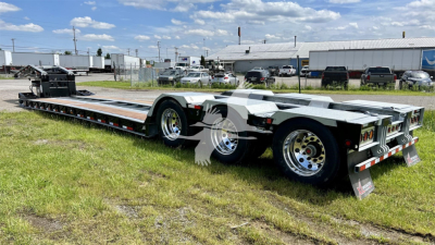 Flatbed trailer showing XL Specialized XL110HDGS with triple-axle rear, aluminum decking, and chrome wheels.