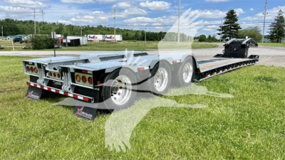 Trailer rear view showing XL Specialized XL110HDGS lowboy trailer with dual rear axles and mud flaps, aluminum deck, and ramp/neck area visible.