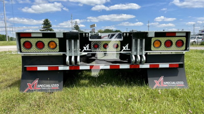 XL Specialized XL110HDGS trailer rear showing reflective taillights, mud flaps with XL logo, and red/white safety stripe