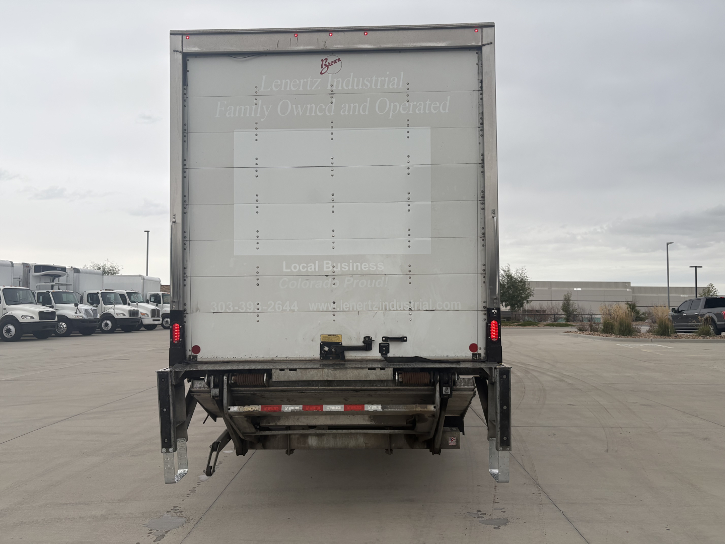Kenworth T270 box truck rear view showing back doors and undercarriage with bumper, taillights, and холд platform.