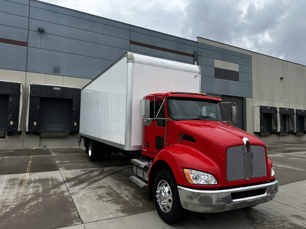 Kenworth T270 box truck in red cab with white box, front left angle view, parked in lot.