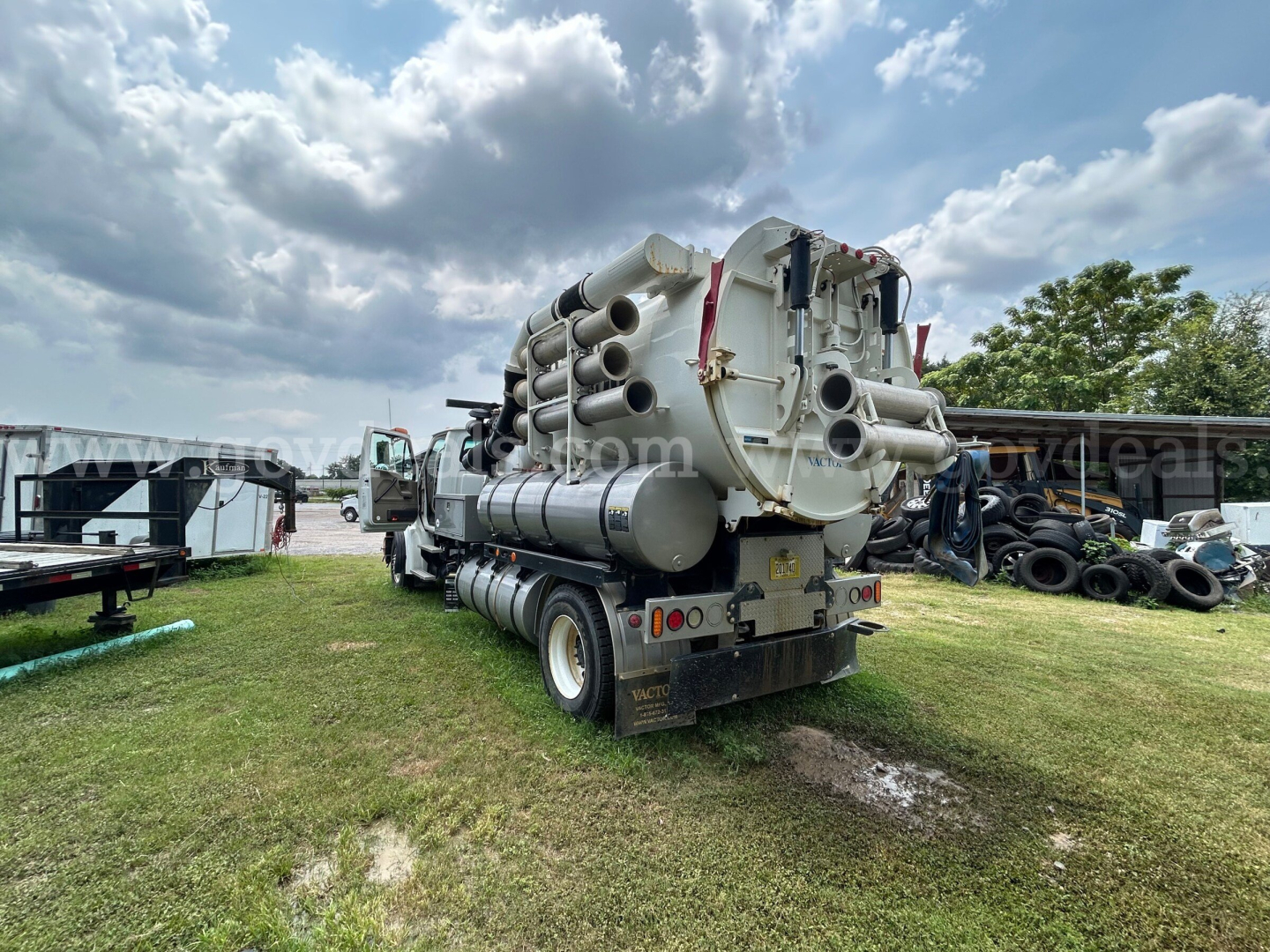 Rear view of a Sterling L7500 vacuum truck with large cylindrical tanks and piping, showing multiple exhaust/vent stacks and dual rear wheels.