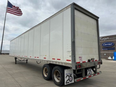 Trailer rear view: 2016 Wabash box trailer with dual rear axles, white metal sides, closed rear doors, and red/white reflective tape along lower edge.