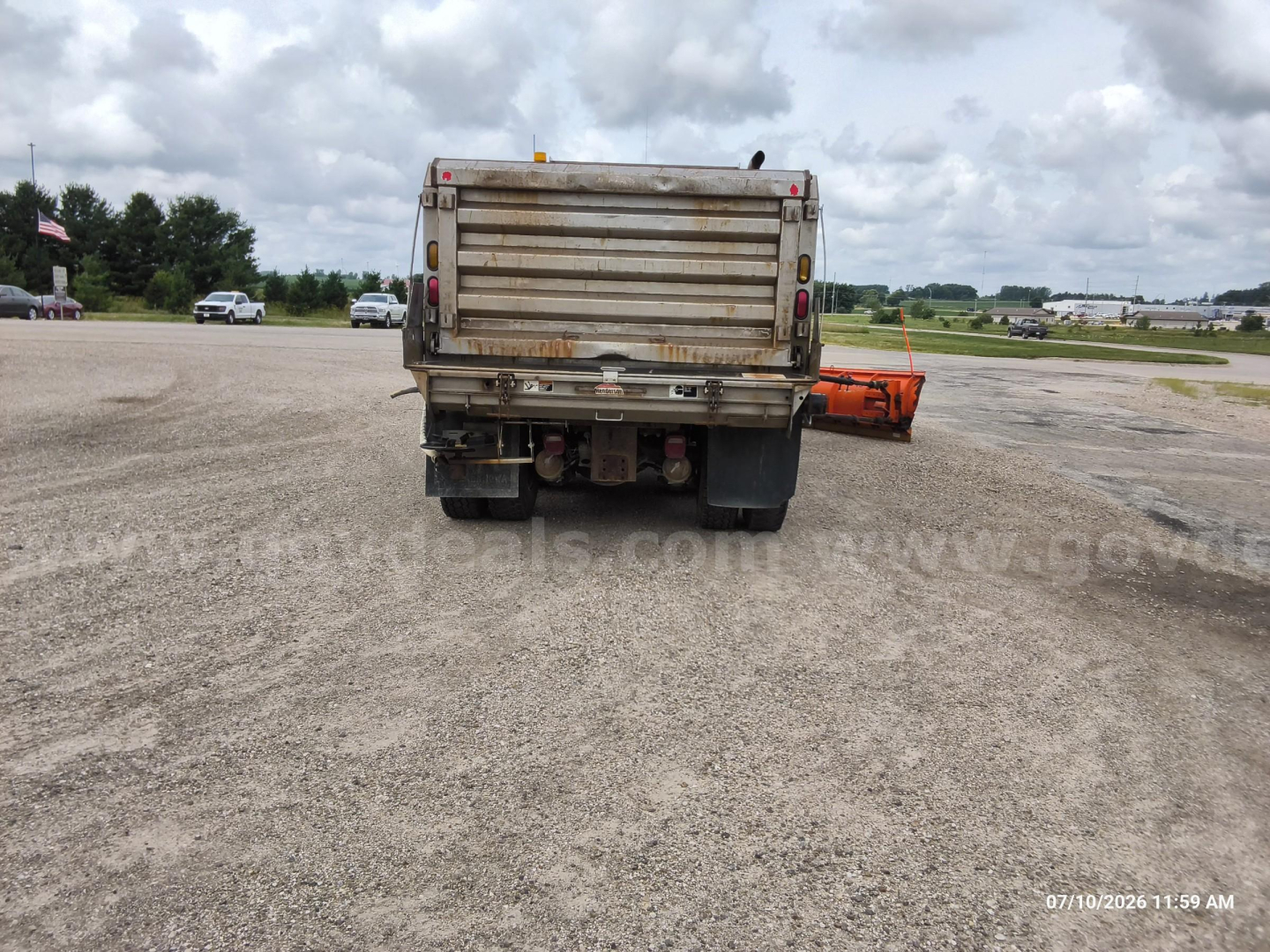 Dump truck showing rear view with tailgate and mud flaps.