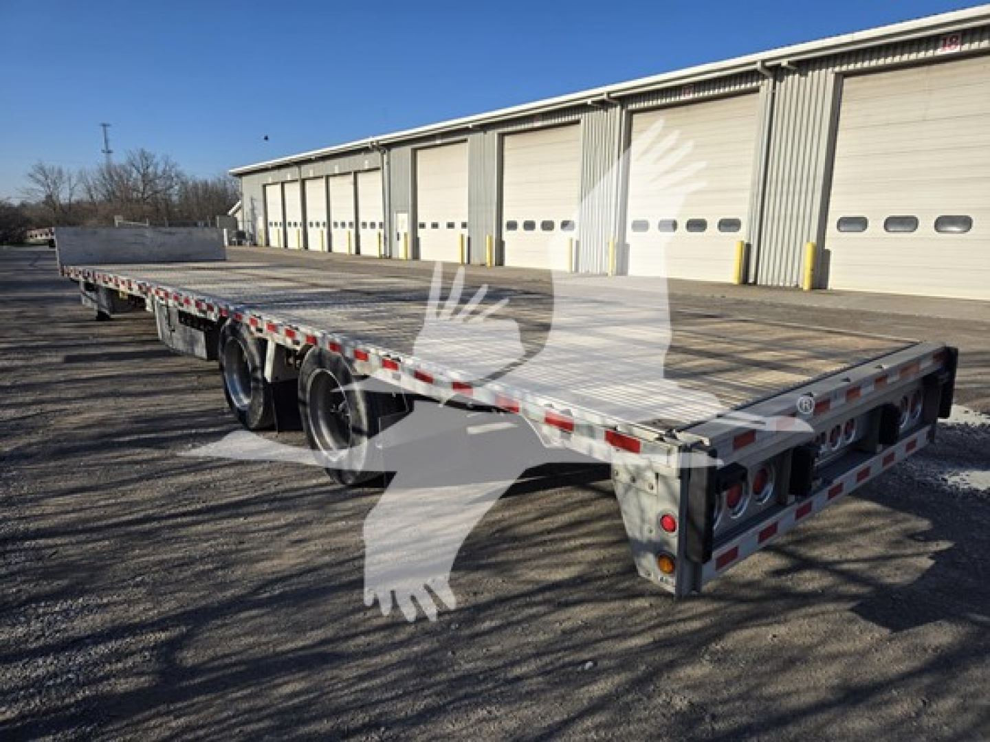 Trailer: 2019 Reitnouer Dropmiser drop deck trailer showing long flatbed with rear dual axles and rear lights.