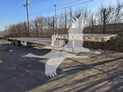 Dropdeck trailer showing long flatbed with RGN style 3-axle setup and reflective tape along edge.