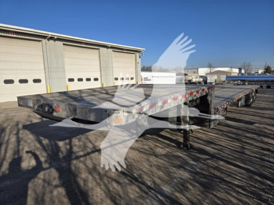 2019 Reitnouer Dropmiser trailer in yard showing drop deck flatbed with multiple axles and wheel chocks.