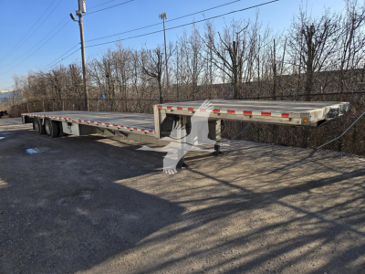 2019 Reitnouer Dropmiser trailer with flatbed deck, gooseneck hitch, dual tandem axles, and reflective safety tape along sides.