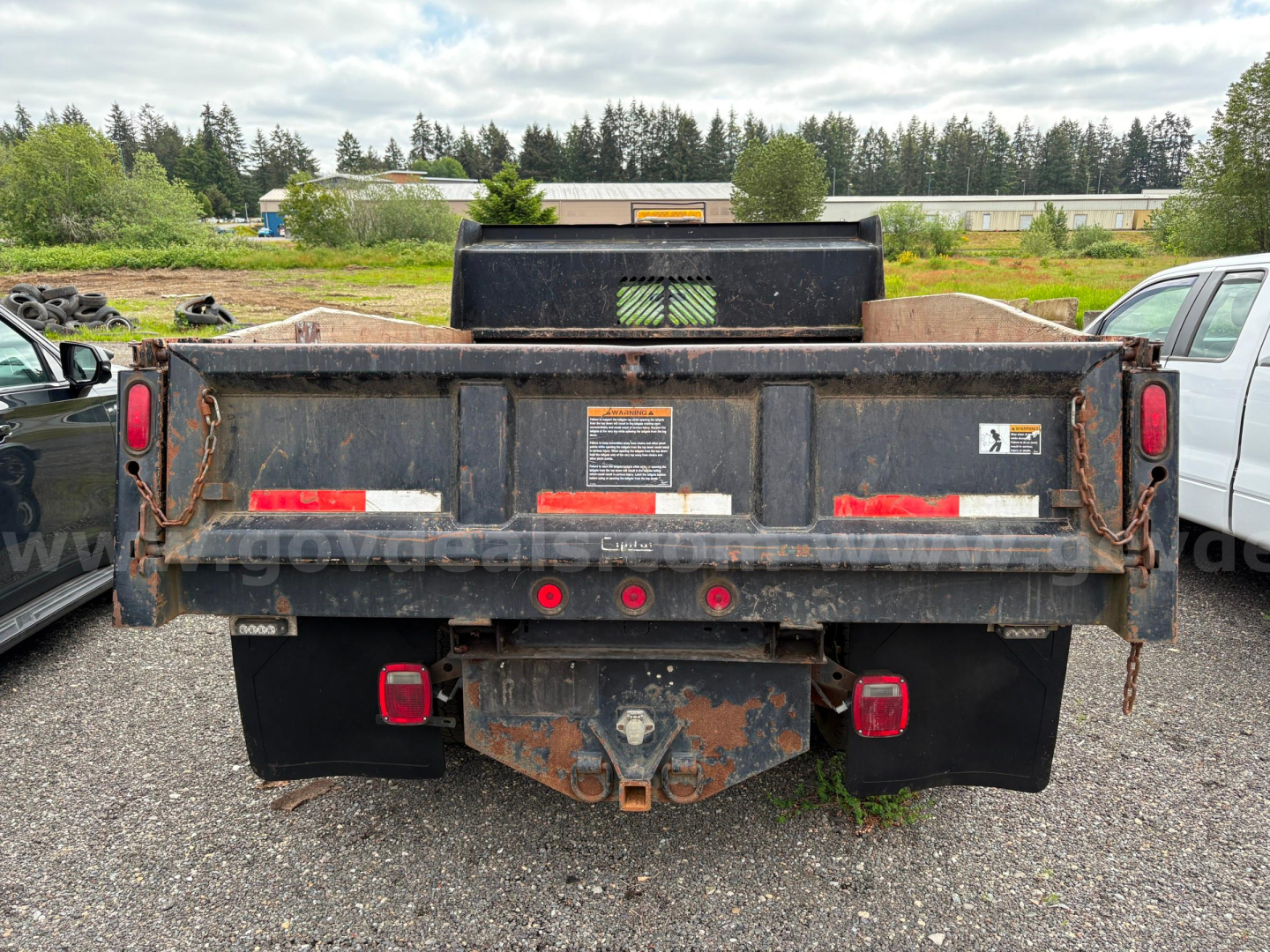 Dump truck bed rear showing hitch, taillights, and warning stickers on a 2008 Ford F350 dump truck.