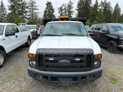 Ford F-350 dump truck front view showing grille with Ford emblem and bumper, with amber clearance lights on cab roof.