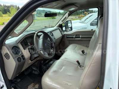 Ford F-350 interior with light gray cloth seats and steering wheel, dashboard, and front doors visible from the driver’s side.
