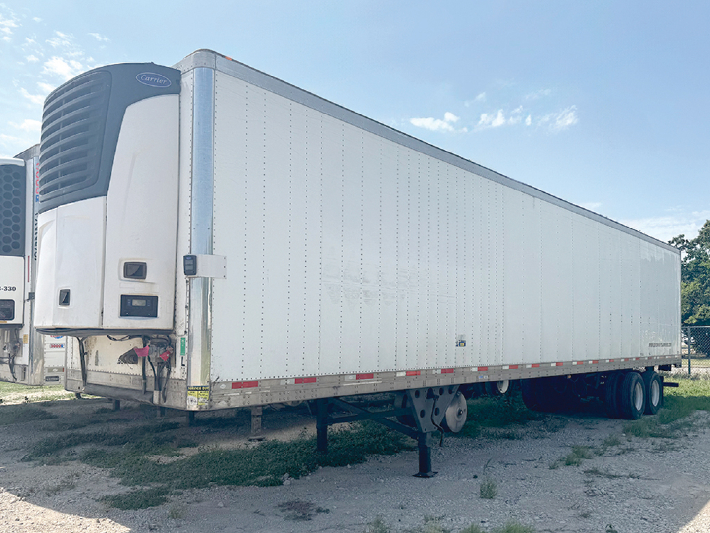 Utility 3000R trailer with Carrier reefers unit at front showing reefer refrigeration unit and raised landing gear.