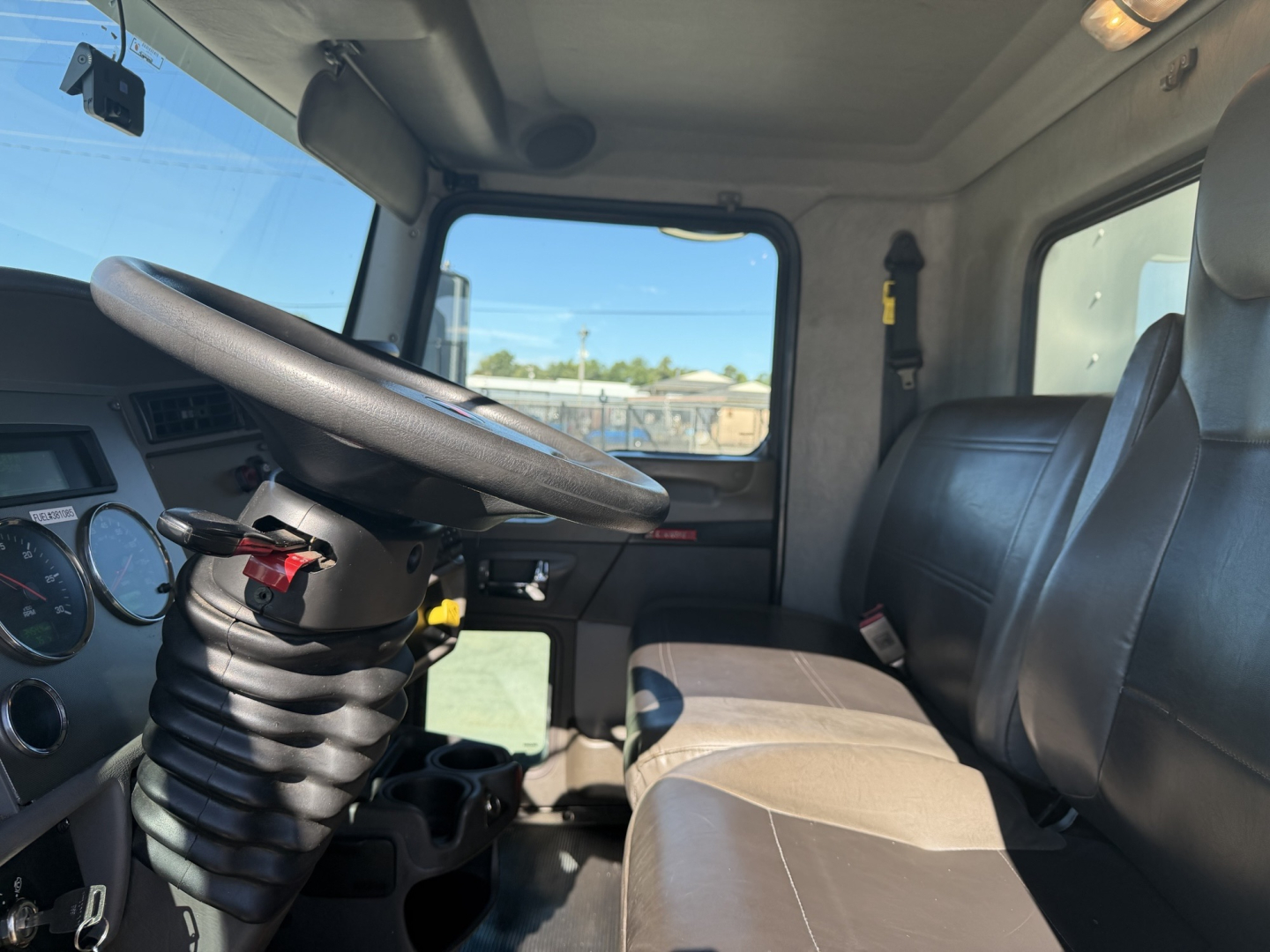 Kenworth T270 cab interior showing steering wheel, driver seat, and dashboard with gauges.