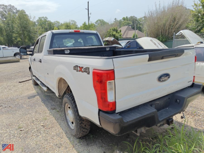 Ford F-250 Super Duty pickup truck rear 4x4 crew cab with white paint and black bumper, open bed with tonneau cover, Ford badge.