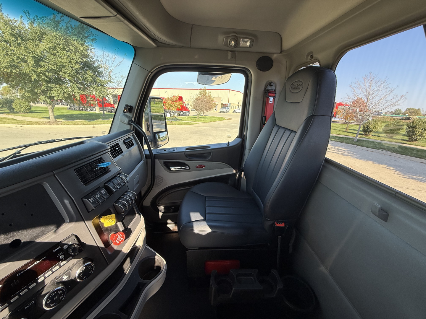 Peterbilt 579 cab interior showing front dashboard and passenger seat with center console and cup holders.