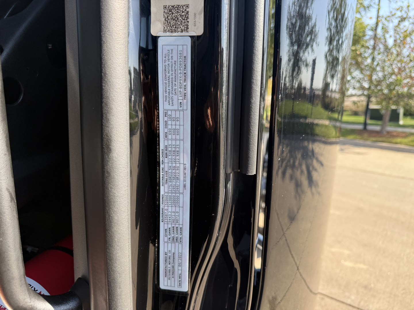 Peterbilt 579 cab interior near door hinge with VIN label and data plate visible on door jamb.