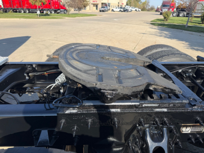 Truc k tractor cab area showing fifth wheel mounting plate and surrounding chassis with spare wheel cradle on a Peterbilt 579. Visible components include black metal frame, connectors, and wiring near the fifth wheel.