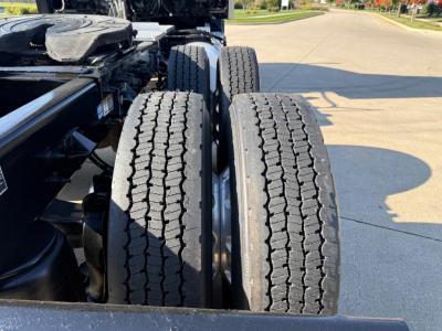 Peterbilt 579 truck chassis with dual rear axles and dual tires, visible tires and frame in daytime.