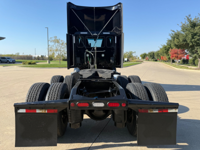 Peterbilt 579 tractor rear view showing fifth wheel, dual rear axles, mudflaps, and chassis hardware.