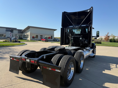Peterbilt 579 truck tractor rear view showing dual rear axles and fifth wheel with high-roof sleeper cab, black body, and exposed chassis.
