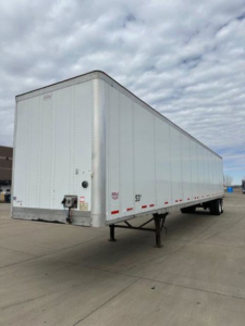 Flatbed semi trailer with white exterior and silver frame showing front left corner and side rails. No identifying markings visible.