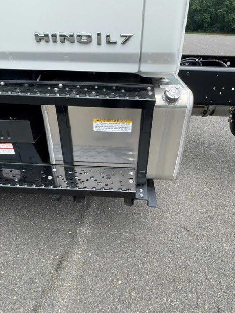 Hino L7 cab chassis rear side showing HINO L7 badge and step/steel bumper with warning label on metal panel.