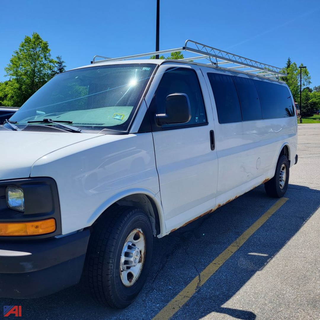 Cargo van showing side view of a white 2012 Chevrolet Express with roof ladder rack and side windows, in-service paint and basic exterior features.
