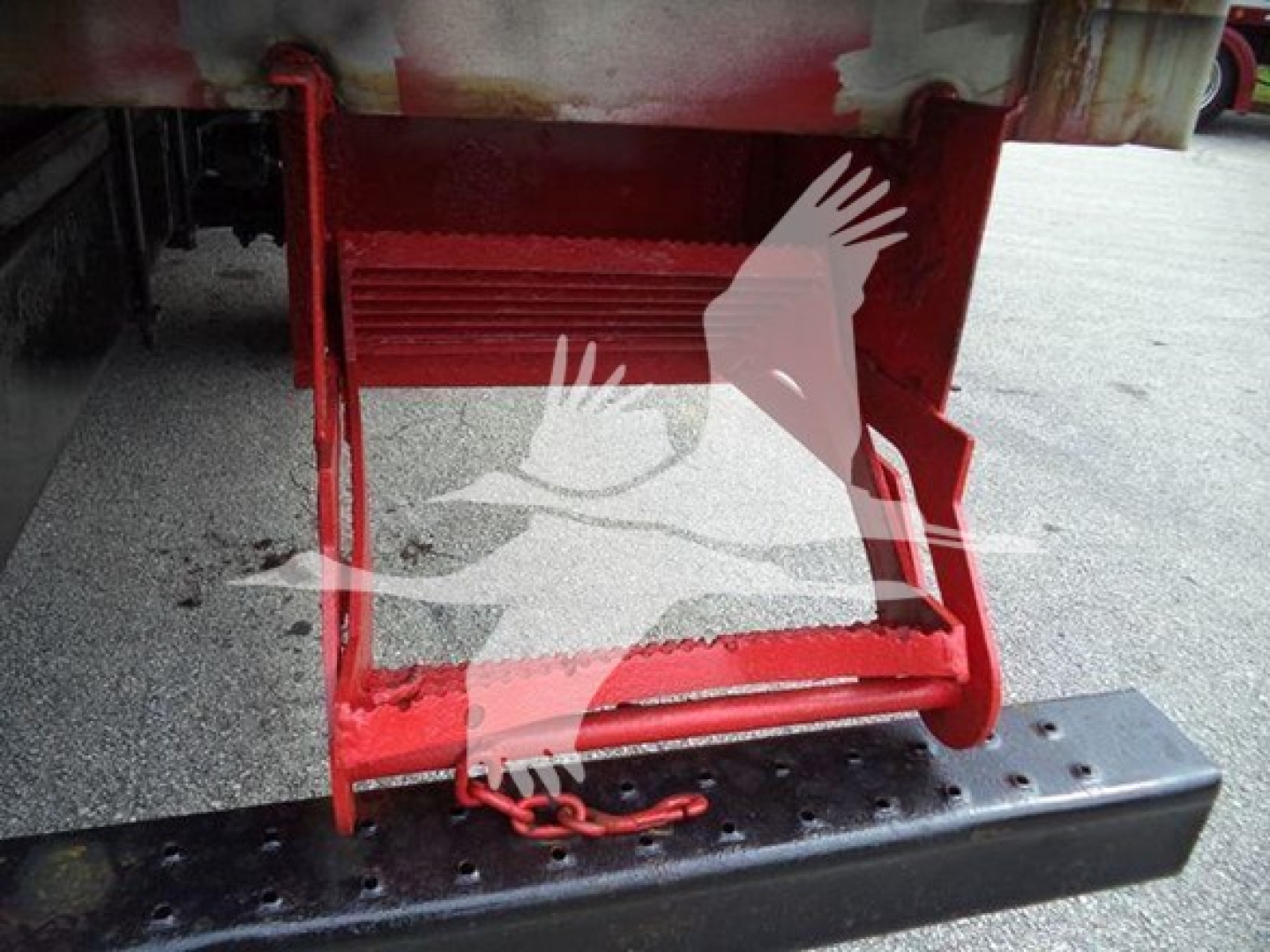 Rear view of a red refrigerated truck step/ladder with lower bumper and safety chain visible.