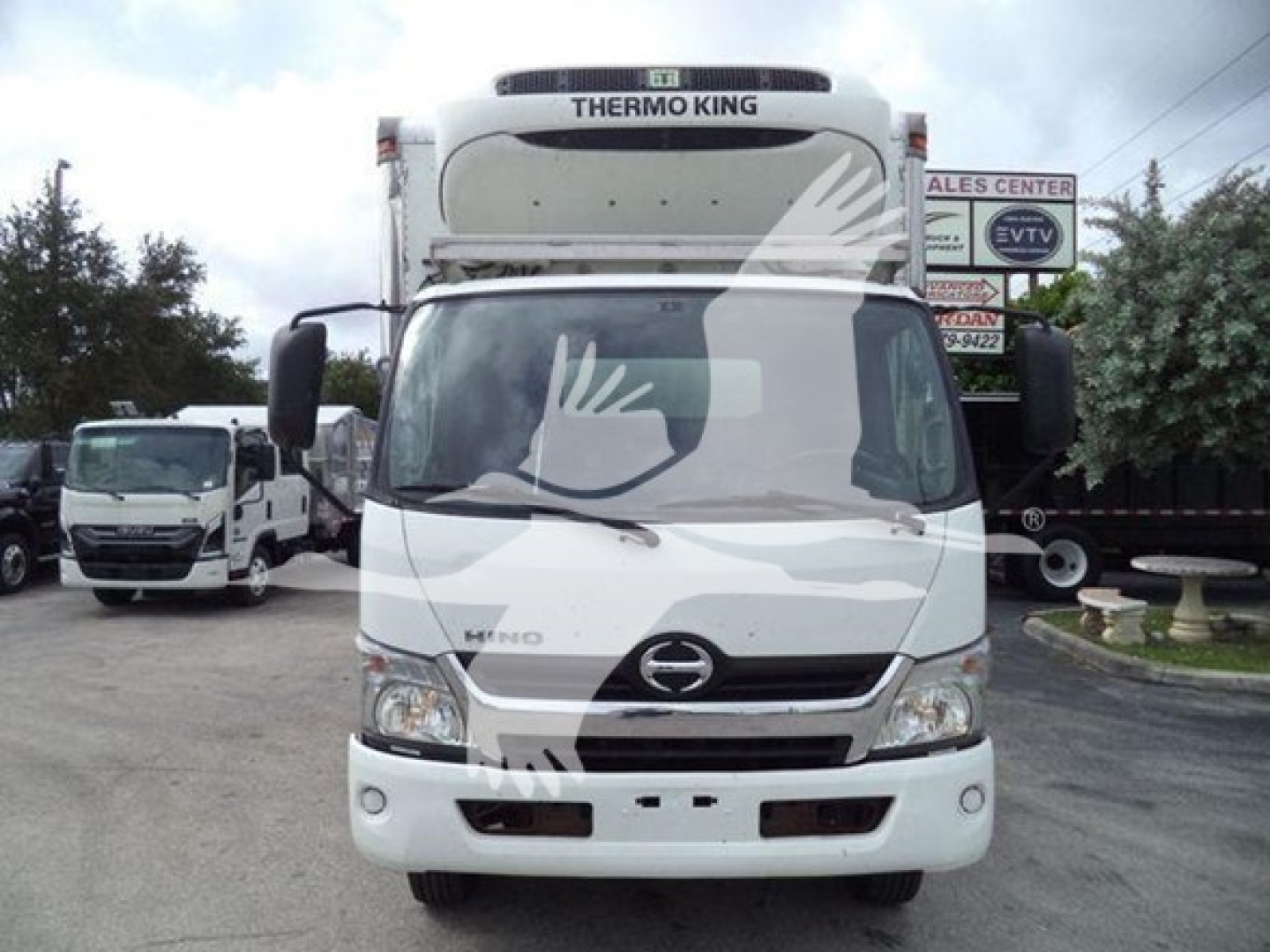 Front view of a white 2019 Hino 195 refrigerated truck with Thermo King unit on top; visible Hino emblem, grille, headlights, and bumper.