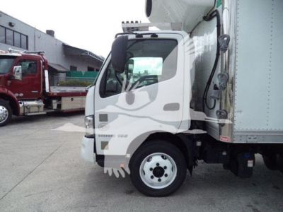 Truck cab of a 2019 Hino 195 refrigerated truck showing front wheel and door area.