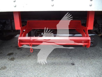 Underbody view of a 2019 Hino 195 refrigerated truck showing red drop-side step and ground surface.
