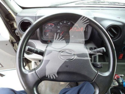 Dashboard and steering wheel of a 2019 Hino 195 refrigerated truck interior. Visible instrument cluster and steering column controls.