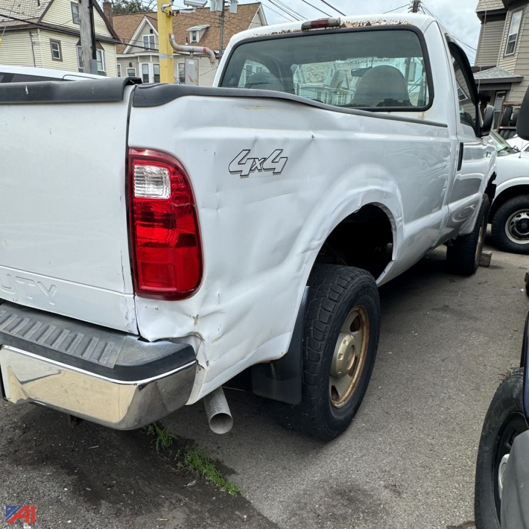 Ford F-350 pickup truck rear-left side with 4x4 badge, white steel bed, bumper, and rear wheel; dented fender and tailgate area visible.