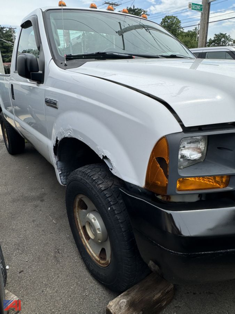 Ford F-350 XLSD pickup cab front-left view showing damaged fender and bumper, white paint, amber turn signals, single cab, 4x4.