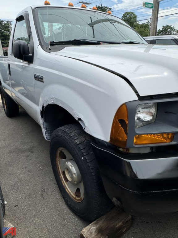 Ford F-350 XLSD pickup cab front-left view showing damaged fender and bumper, white paint, amber turn signals, single cab, 4x4.