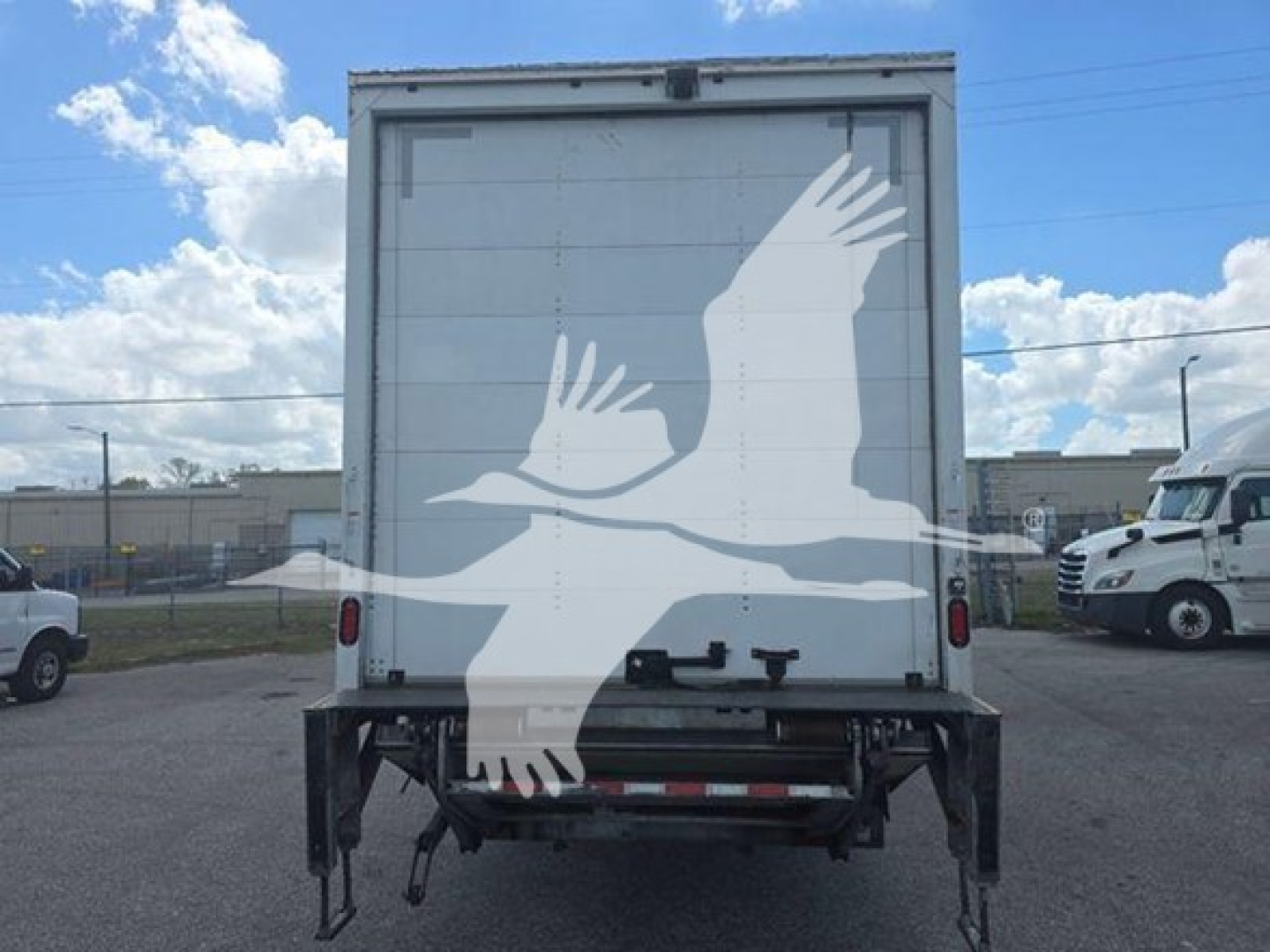 Truck rear showing box cargo area with graphic of flying geese on doors.
