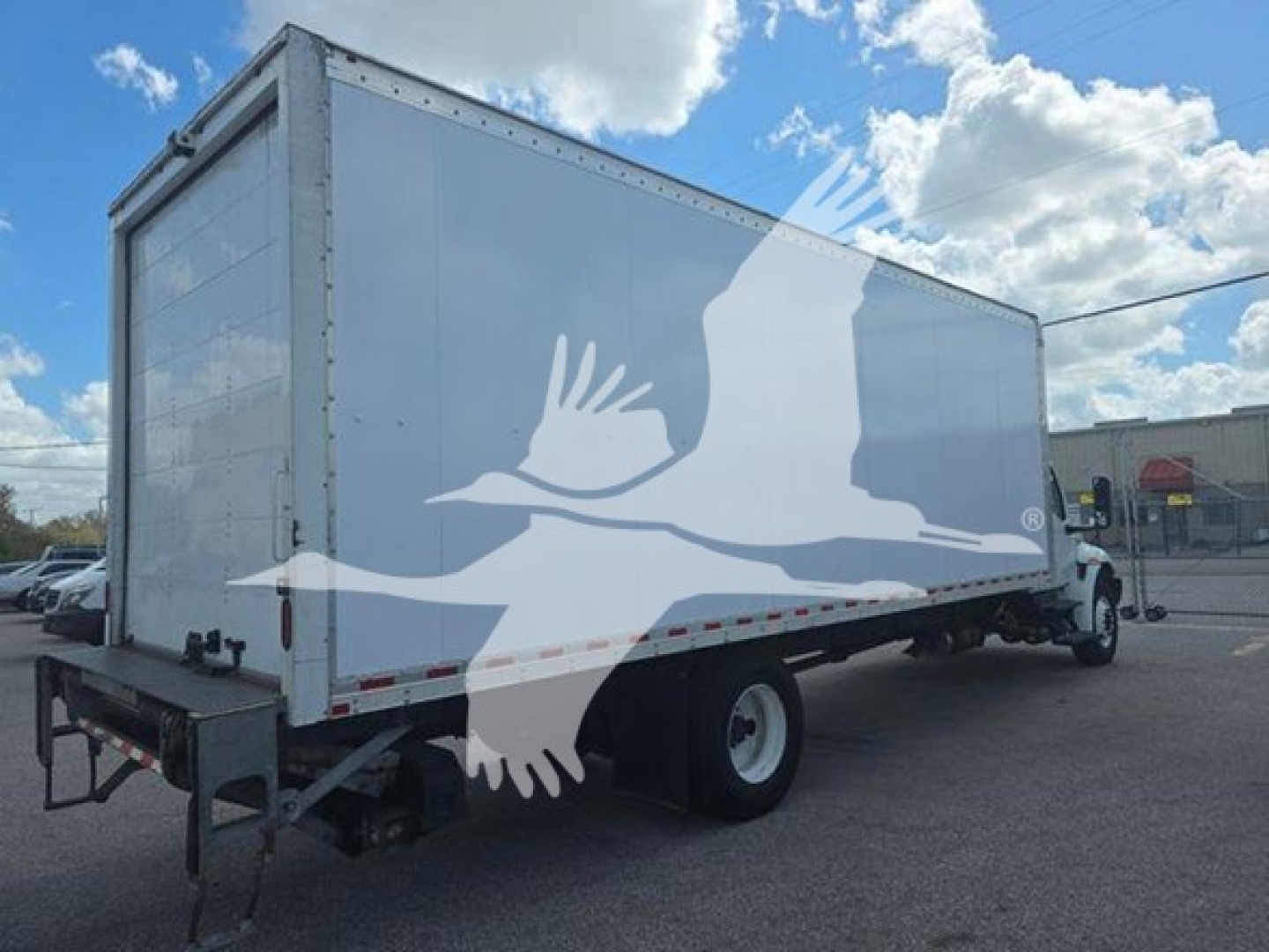 Box truck showing side view with white cargo box and rear wheels.