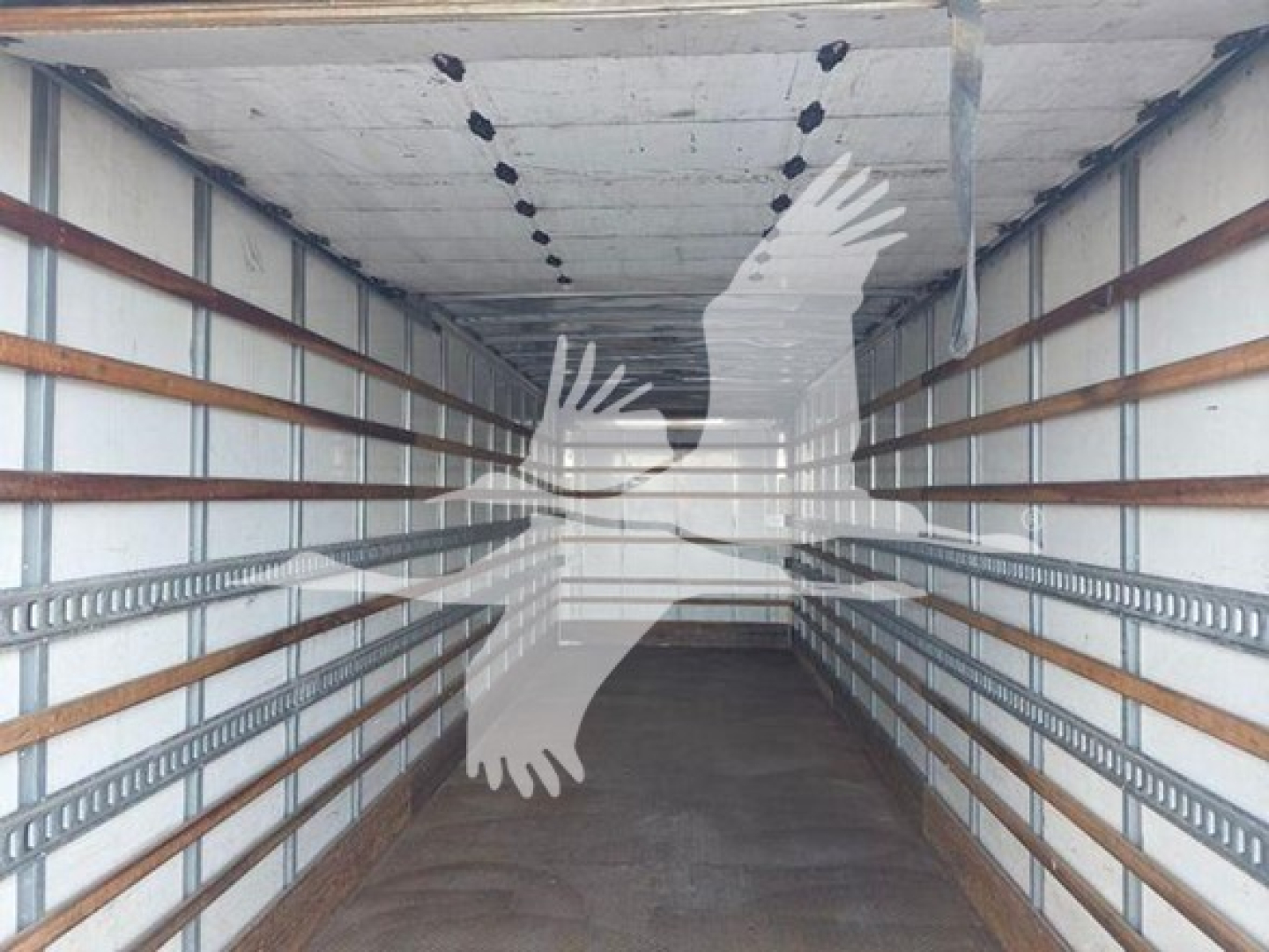 No image of the truck engine; image shows empty trailer interior with overhead lighting and side rails.