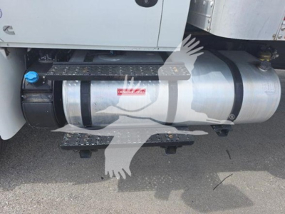 Truck side view showing horizontal cylindrical fuel tank with blue cap and black strap mounting in 2020 International MV truck.