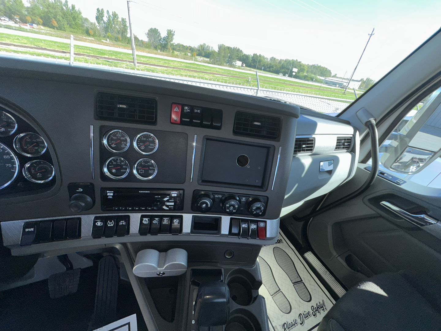 Dashboard cockpit of a Kenworth T880 showing multiple gauges, control switches, and center stack.