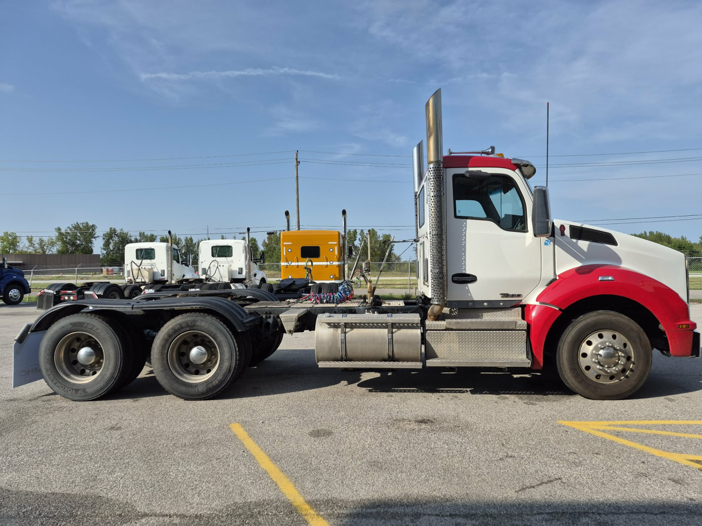 2018 Kenworth T880 conventional daycab truck side profile showing dual rear axles and exhaust stacks.