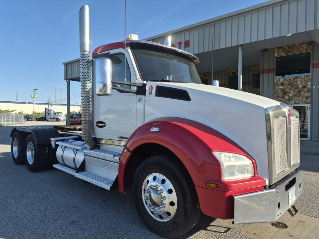 Kenworth T880 conventional daycab showing chrome fuel tanks and exhaust stack with white cab and red fenders.