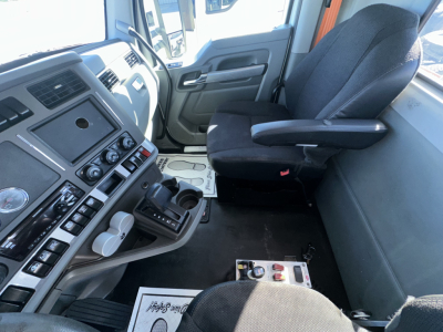 Kenworth T880 cab interior showing steering column, dashboard controls, and driver seat with center console and dashboard panels.