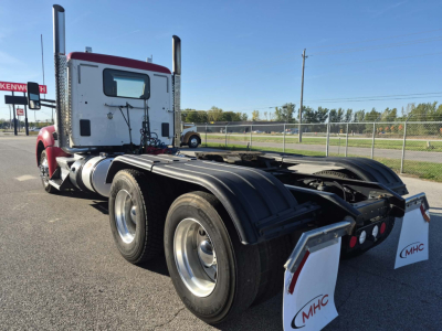 Kenworth T880 single rear-axle tractor chassis view showing dual rear wheels, fifth wheel, and white rear fenders with MHC logo.