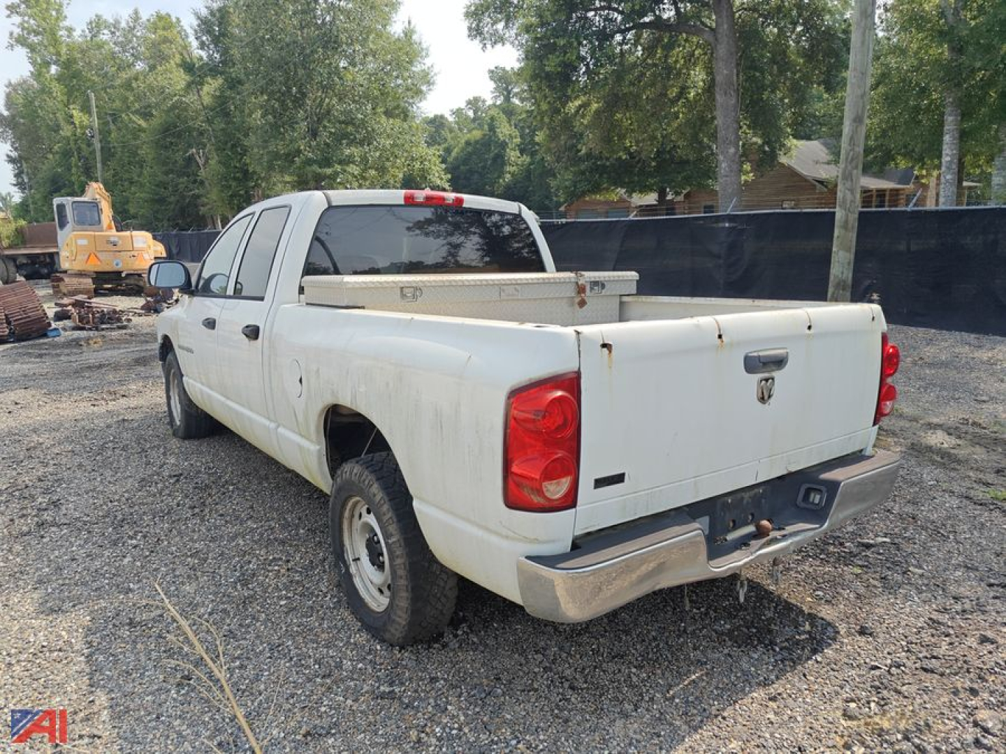Dodge Ram 1500 crew cab pickup truck rear view showing white paint, quad cab, long bed with toolbox, tailgate, and red taillights.