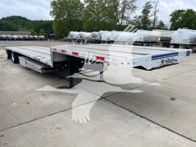 Transcraft D-Eagle II drop deck trailer showing exterior white aluminum deck with blue stripe, rear ramps, and dual axle configuration.