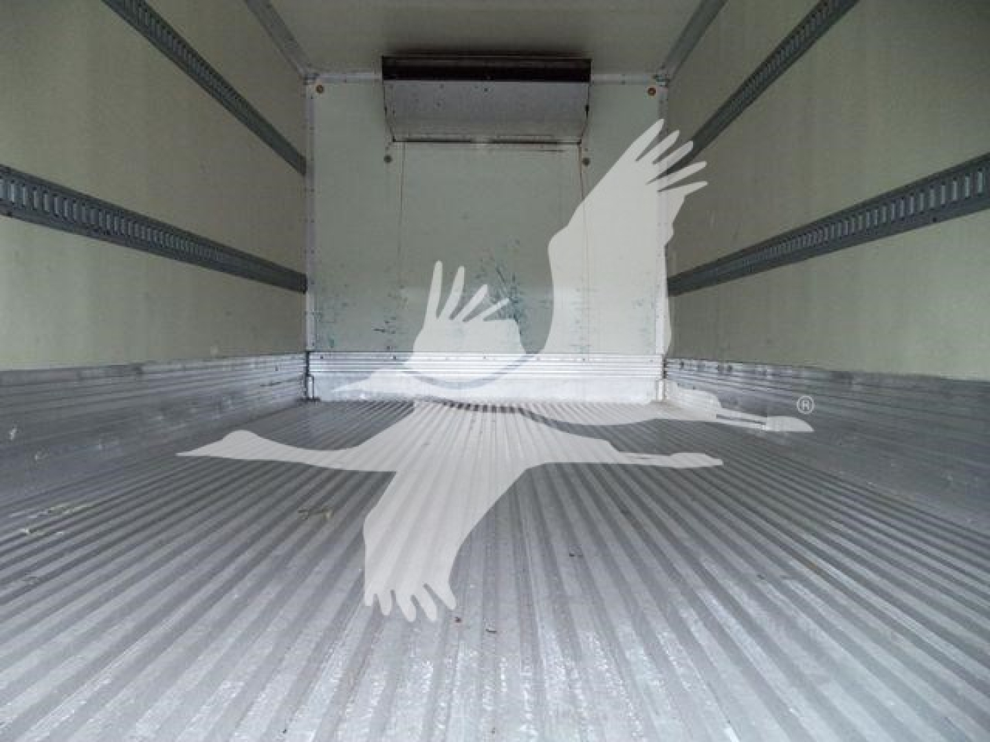 Isuzu NPR refrigerated truck cargo area interior with metal ribbed floor and side rails.