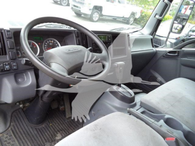 Isuzu NQR cabin interior showing steering wheel and dashboard with gear shifter and central console.